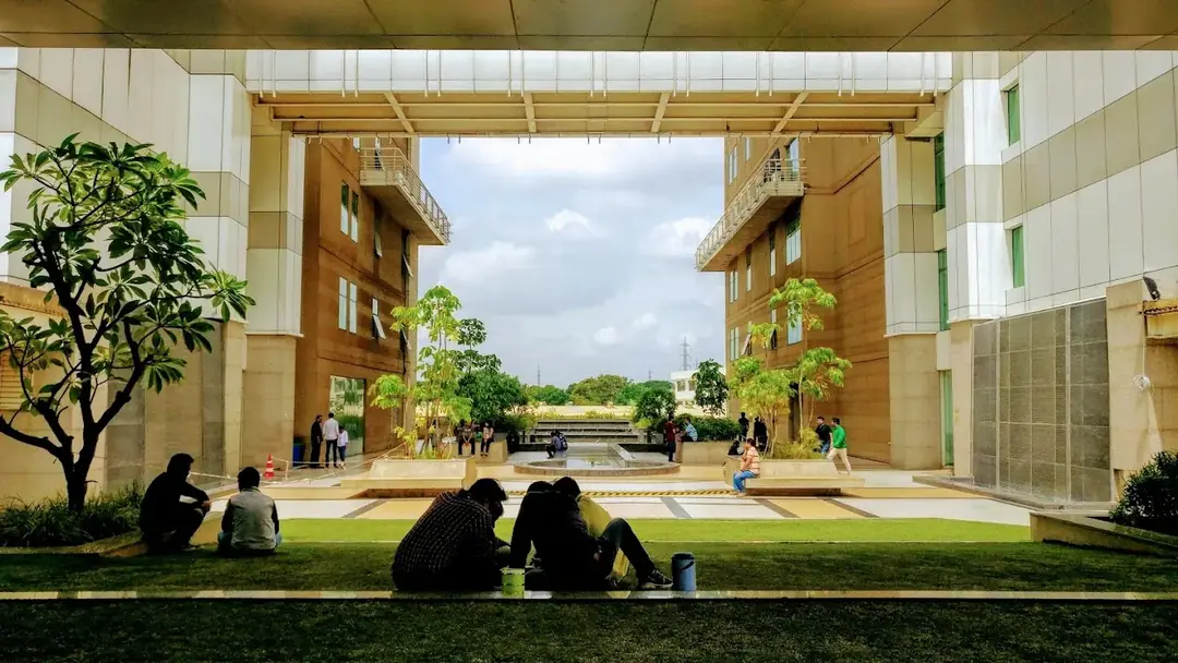 People resting on the lawn between Capgemini's office blocks
